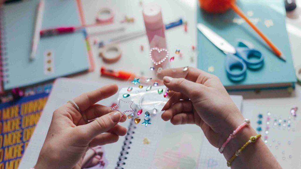 An overhead view of applying planner stickers to a blank notebook